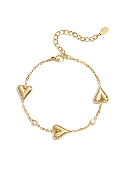 Armband met drie massieve harten en steentjes -goud